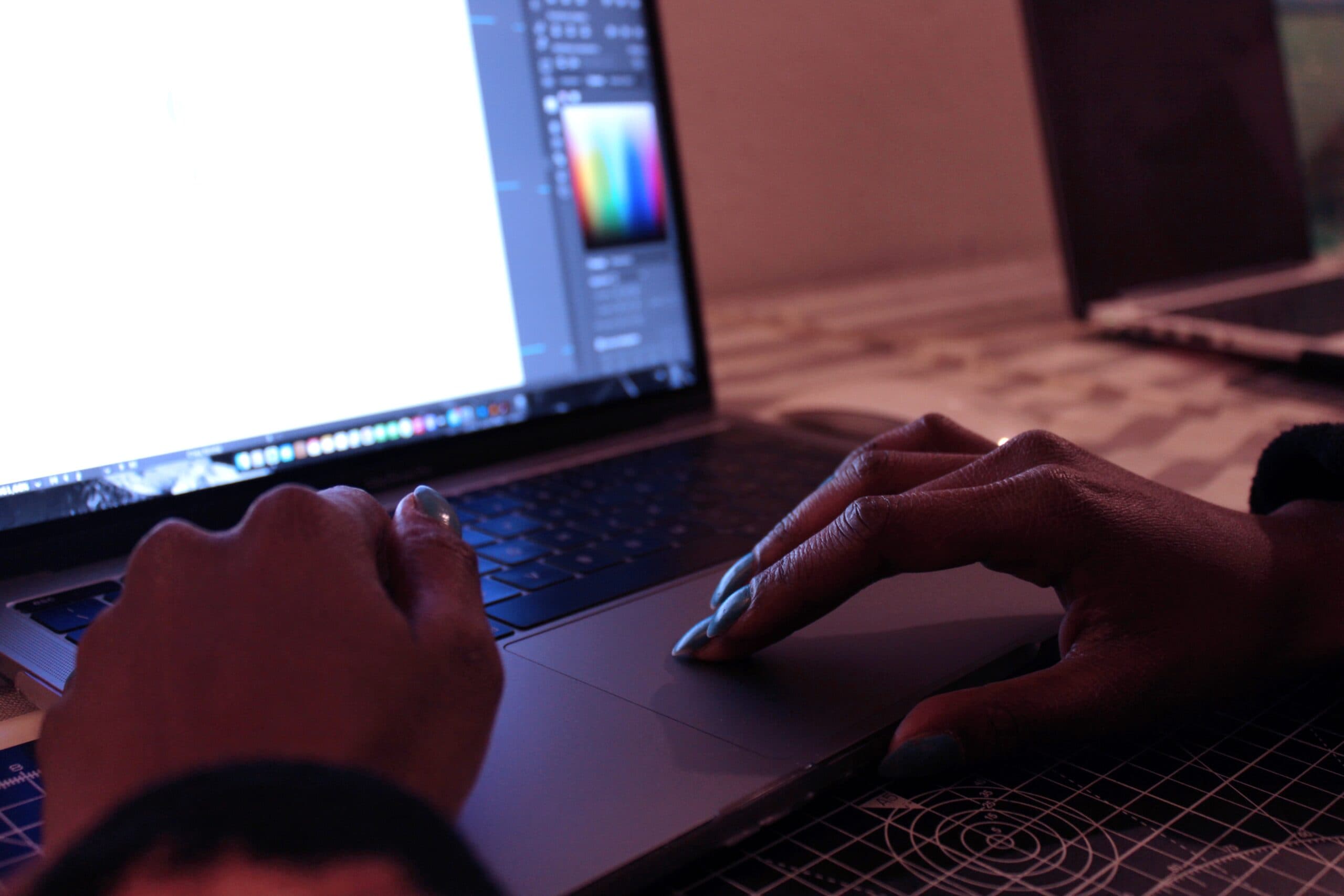 Man's hands doing graphic design on a laptop