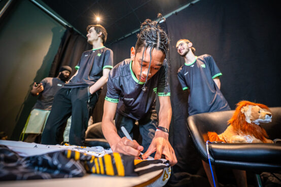 Students signing the main Student Champs Jersey for 2023